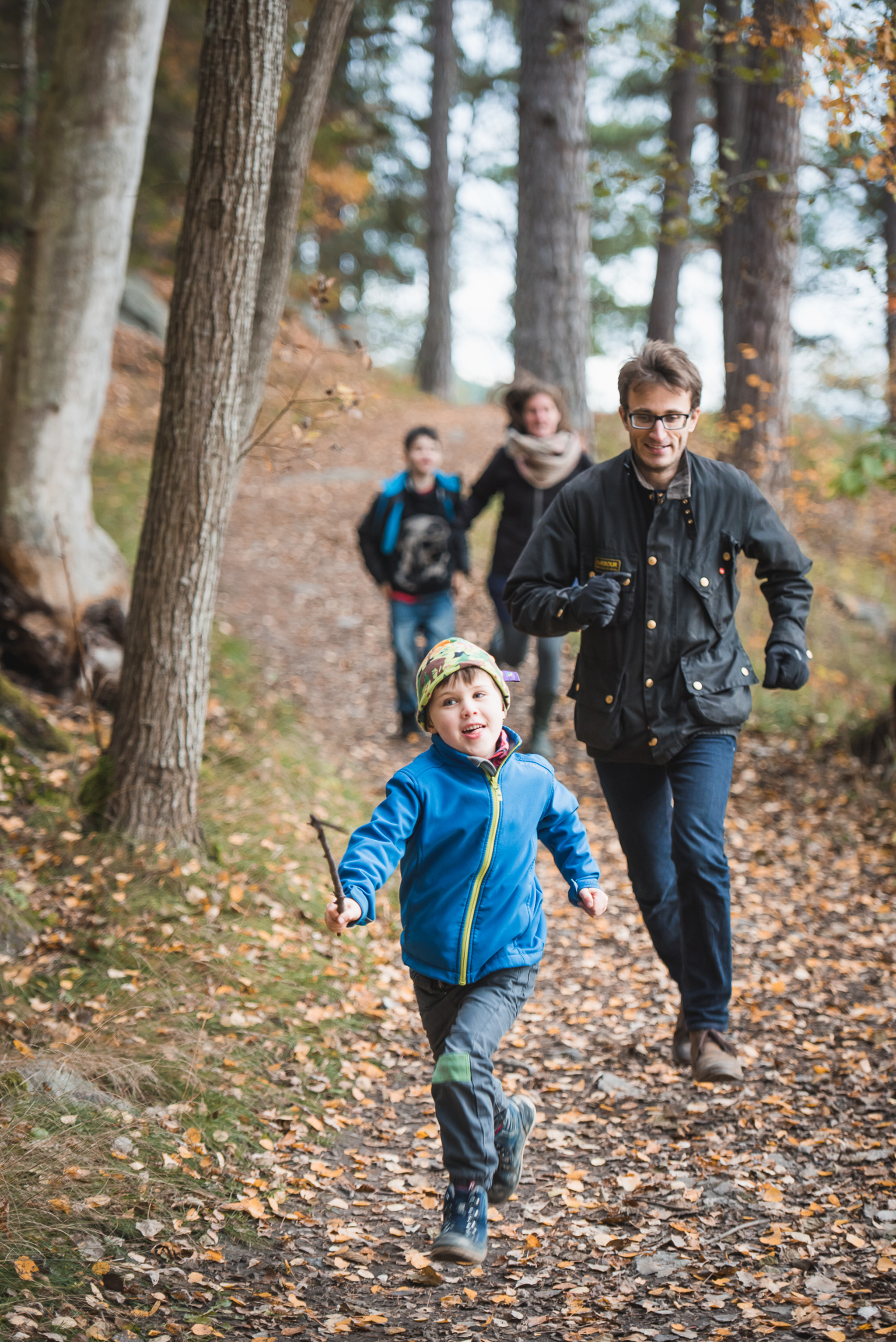 family running among autumn leaves